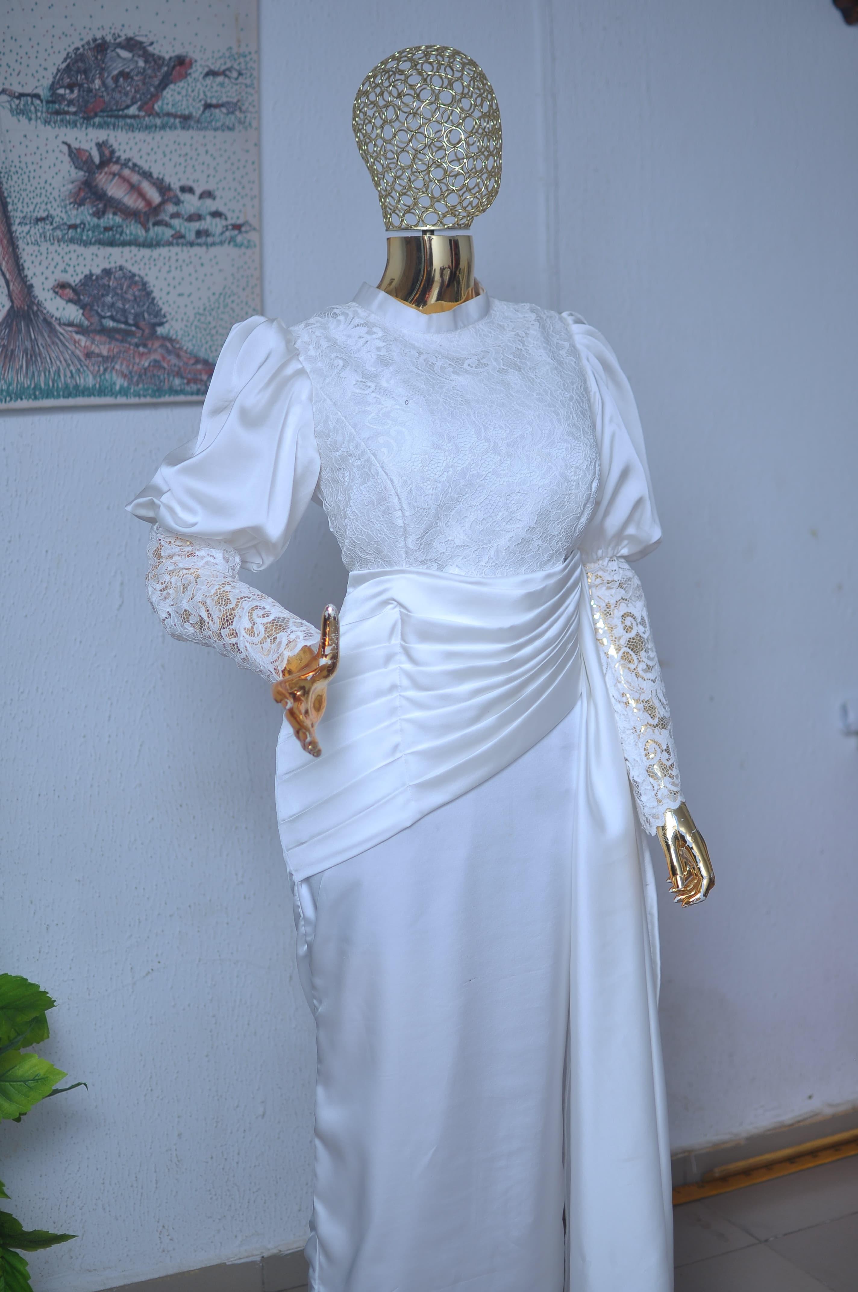 Ivory satin gown with lace sleeves and a pleated, draped bodice.