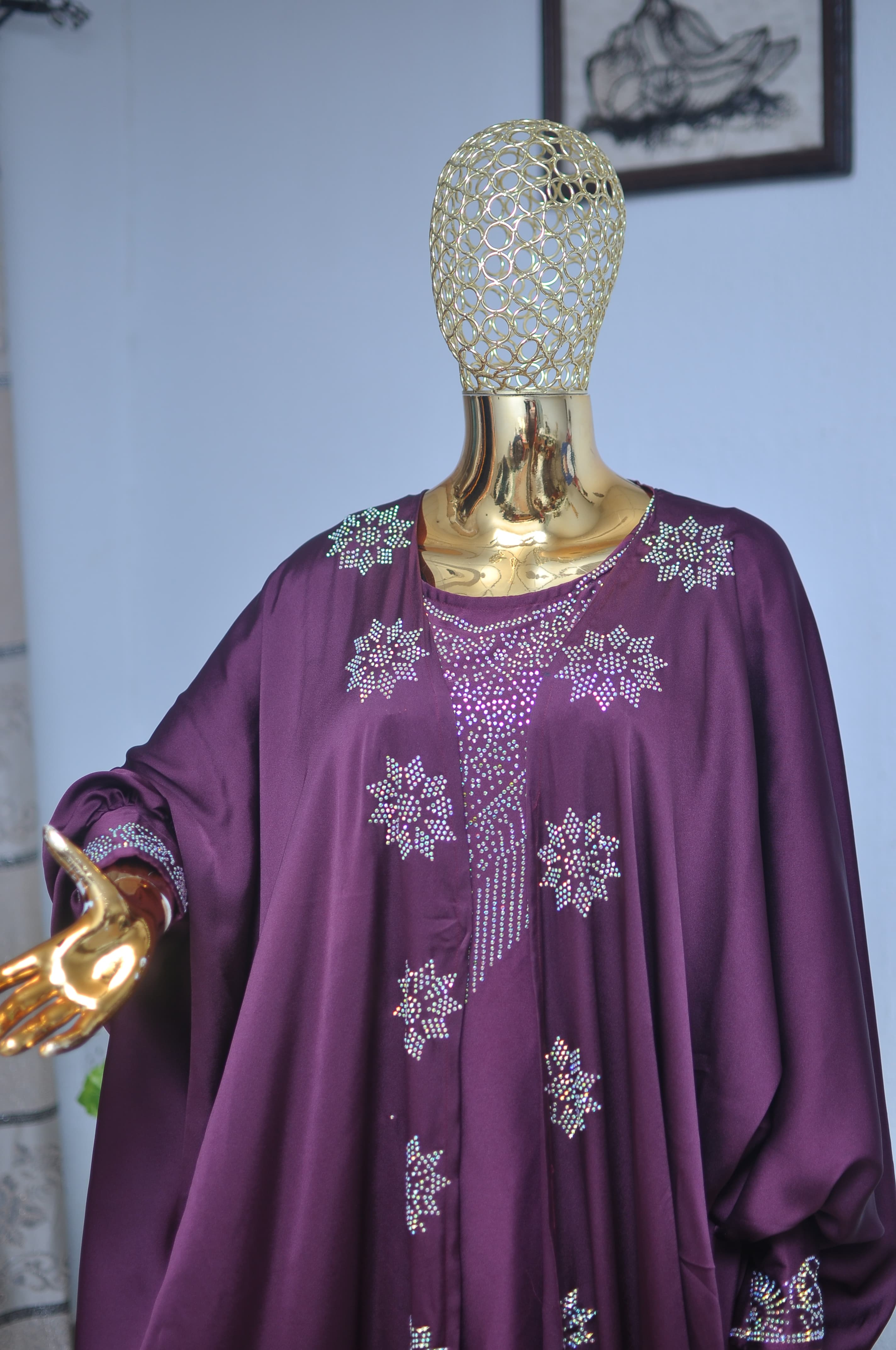 Deep plum satin gown with crystal star appliqués and voluminous sleeves.