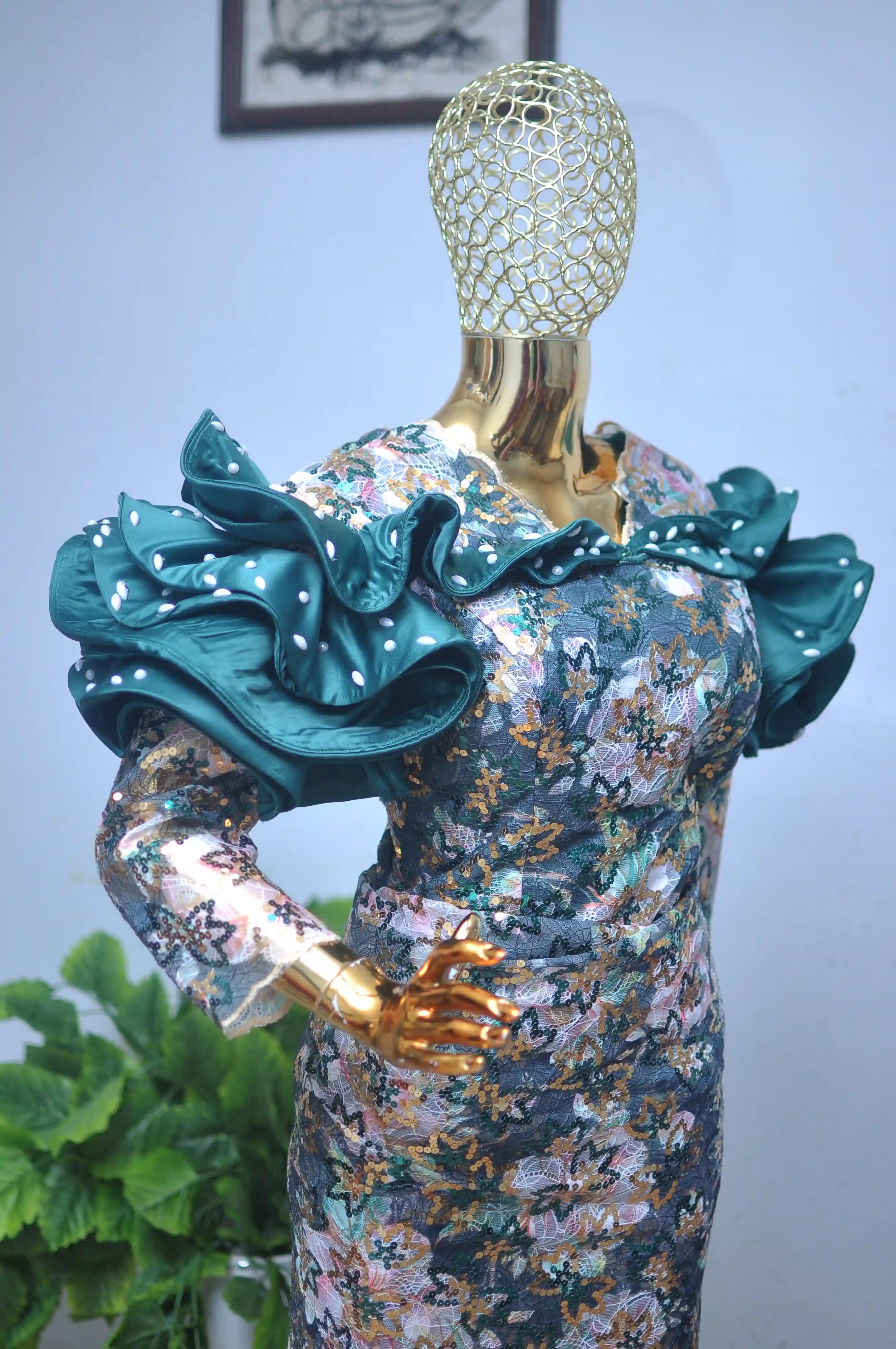 Teal sequin lace gown with dramatic ruffled, pearl-dotted shoulders and sleeves.
