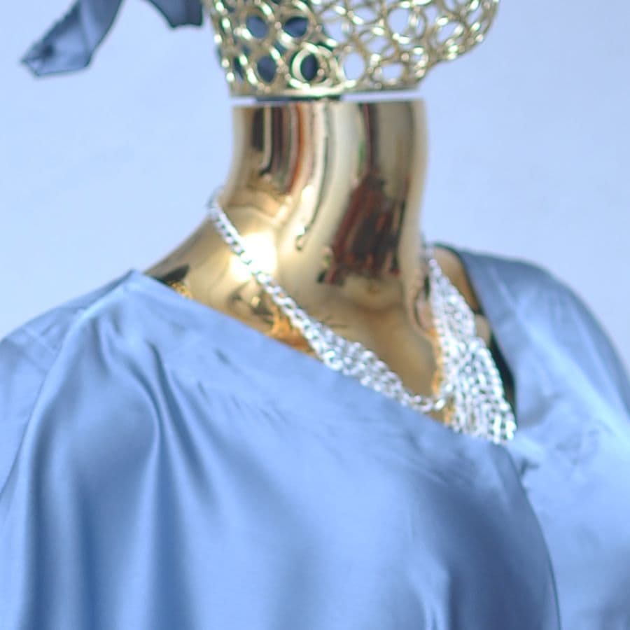 Close-up of a crystal-set neckline on slate-blue satin.